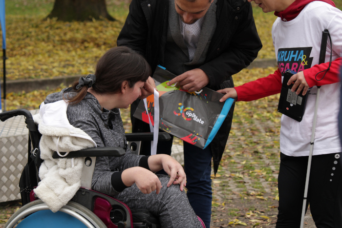 a participant in a wheelchair receives a medal from a representative of the City of Zagreb